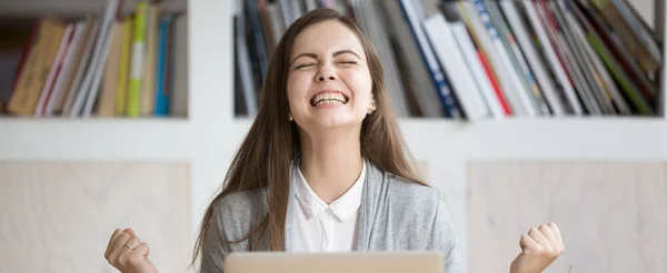 Lycklig kvinna sitter vid arbetsplatsen firar stora möjligheter i arbetet — Stockfoto