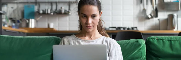 Horizontal photo mixed race female sitting on couch using computer — Stock Photo, Image