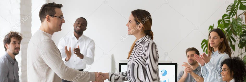 Company ceo handshaking with promoted female employee congratulating with success