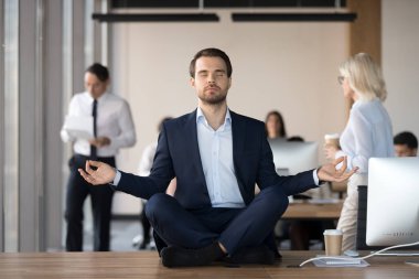 Ofis çalışma masası üzerinde meditasyon takım elbiseli sakin işadamı