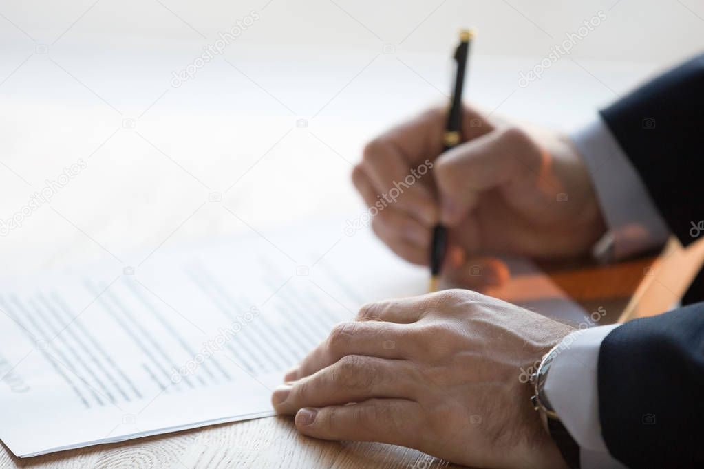 Close up view of male hand signing business contract concept