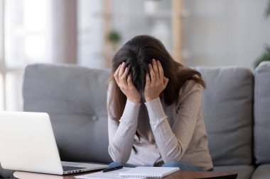 Kafa elinde tutan sinirli laptop oturan kadın üzgün