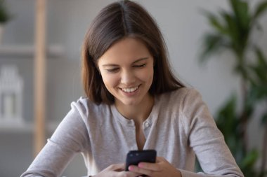 Mutlu kız sosyal ortamda sohbet smartphone kullanarak cep telefonu tutan