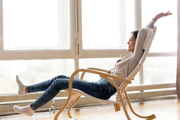 Carefree young woman relaxing on comfortable rocking chair at home — Stock Photo, Image