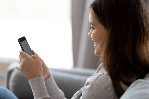 Happy young woman holding smartphone using new mobile apps — Stock Photo, Image