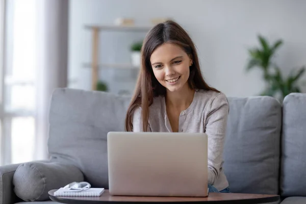 Sorrindo menina adolescente usando laptop para estudo on-line em casa — Fotografia de Stock