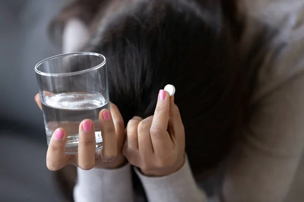 Sad depressed woman holding pill and glass of water — Stock Photo, Image