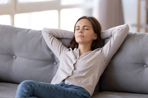 Mladá uklidnit žena chlazení relaxační šikmou na pohodlné pohovce — Stock fotografie