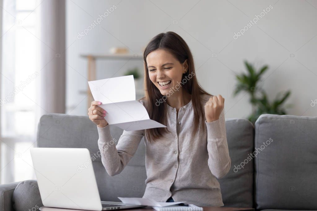 Excited girl holding mail letter feels happy reading great news