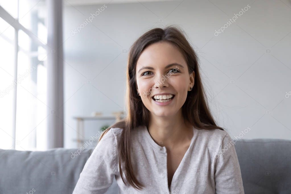 Smiling teen girl talking by video call looking at camera