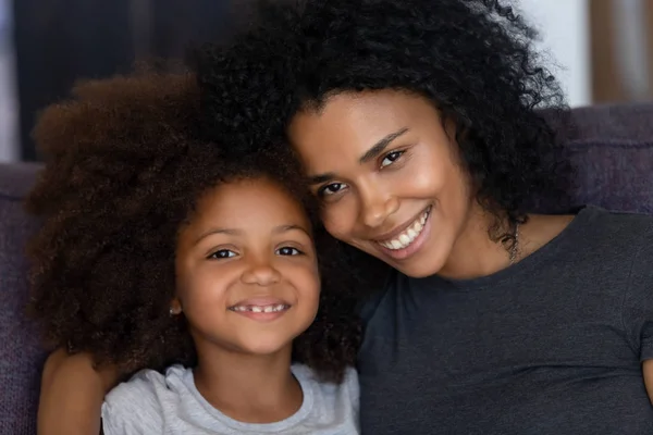 Linda filha africana com mãe negra de ligação olhando para a câmera — Fotografia de Stock