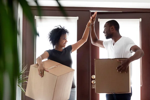 Happy african couple giving high five celebrating moving day — Stock Photo, Image