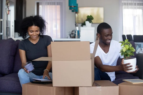 Africano americano feliz pareja desembalaje cajas de cartón en sala de estar —  Fotos de Stock