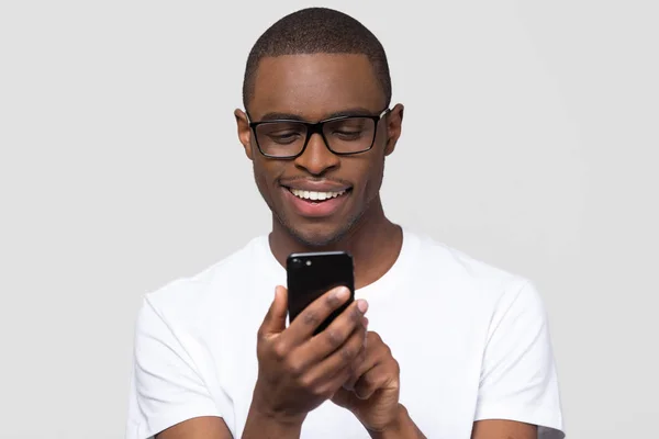 Счастливый молодой африканский человек, использующий смартфоны приложения социальных сетей — стоковое фото