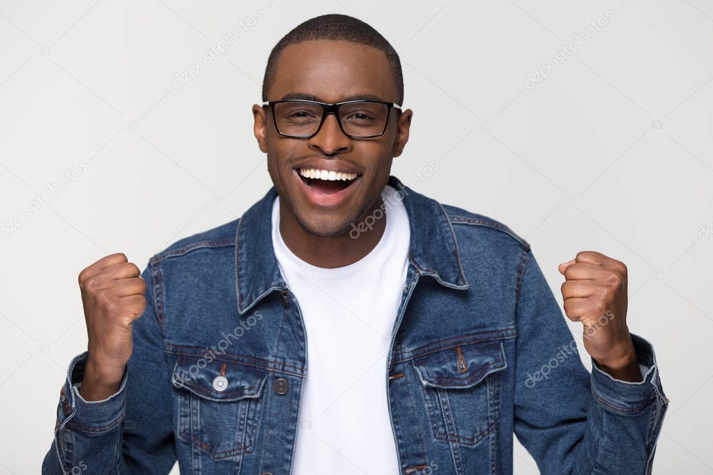 Excited african american man feeling winner triumphant looking at camera