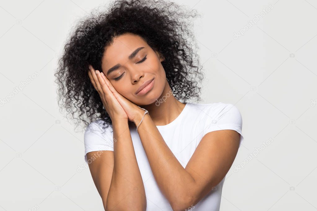 African woman pretending sleeping with head on hands eyes closed