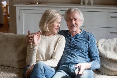 Çekici eş kanepede oturup tv izlerken Orta yaşlı