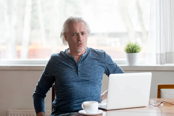 Mature man working on pc feels sudden back pain — Stock Photo, Image