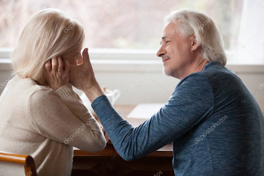 Side view aged husband touching stroking face of beloved wife