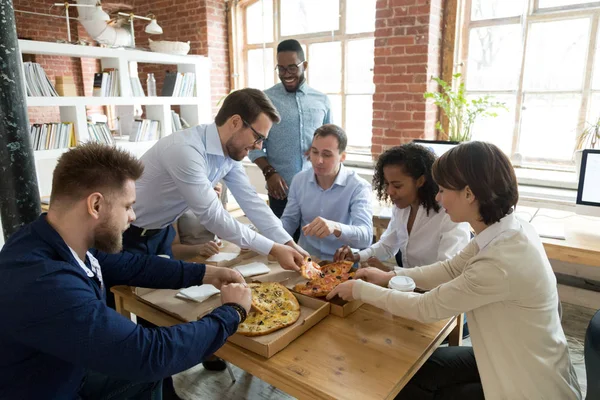 Happy diverse staff people sharing pizza at break in office