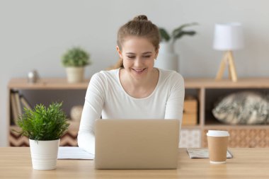 Gülümseyen bin yıllık kadın çalışma veya eğitim dizüstü evde kullanma