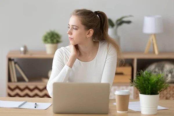 Serious woman looking away searching new ideas working on laptop — Stock Photo, Image