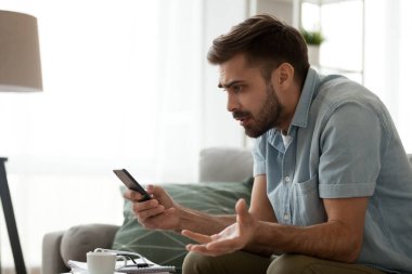 Kızgın, şaşkın adam taburcu holding telefon spam mesaj tarafından rahatsız