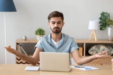 Sakin sakin genç adam pratik yoga iş yerinde mola