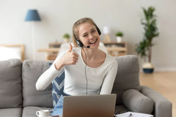 Smiling woman wearing headset showing thumbs up looking at camera — Stock Photo, Image