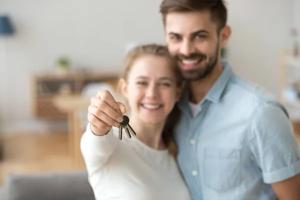 Lykkelig ung gift familie par holder nøgler til ny lejlighed - Stock-foto