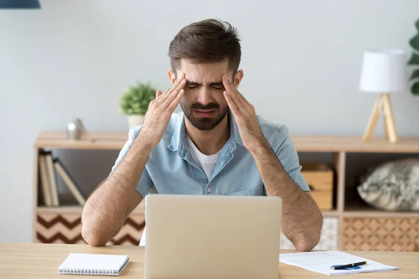 Hombre cansado estresado que tiene dolor de cabeza terrible después del trabajo de la computadora — Foto de Stock