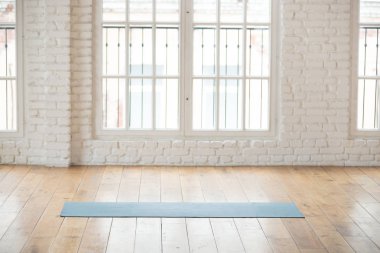 Boş fitness salonunda unrolled yoga mat