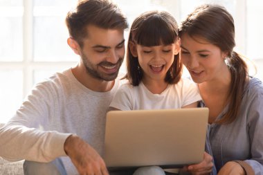Neşeli anne baba ve çocuk kızı dizüstü evde kullanma