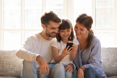 Küçük çocuk kızı holding cep telefonu zevk mobil app kullanarak