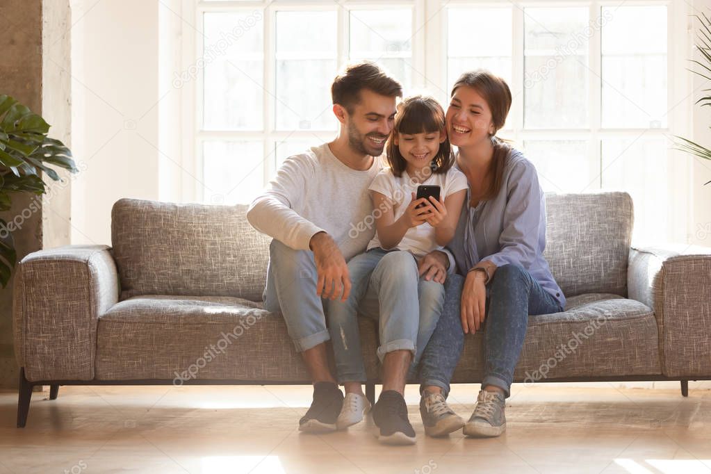 Happy family and kid having fun with smartphone at home