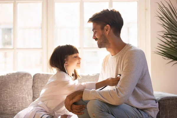 Kleine Tochter spielt Spiel als Ärztin und hat Spaß mit Papa — Stockfoto