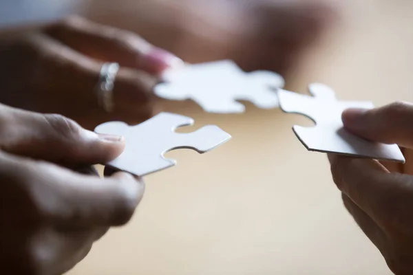 Close up of associates holding puzzle pieces — Stock Photo, Image