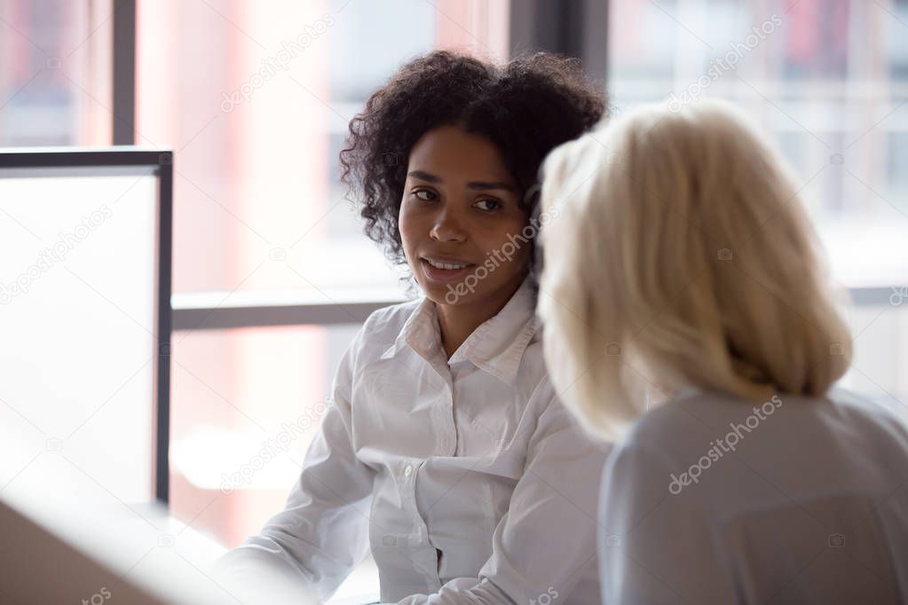 Diverse people negotiating in office, focus on black female