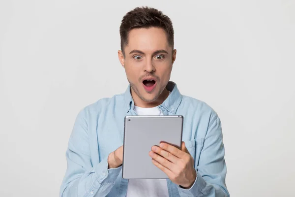 Amazed happy guy using digital tablet excited about online news — Stock Photo, Image