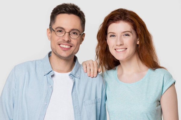 Молодая счастливая романтическая пара смотрит в камеру на заднем плане
