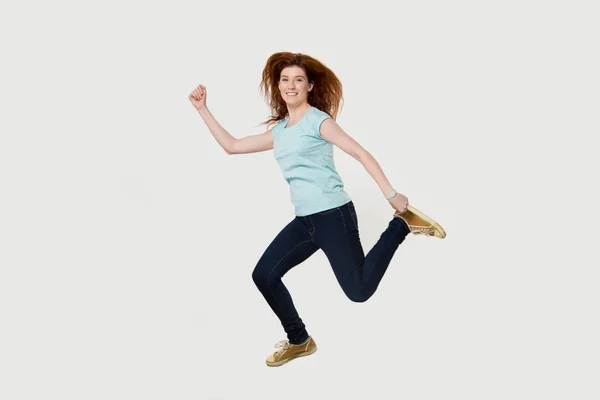 Happy active fit woman running hurrying jumping in air — Stock Photo, Image