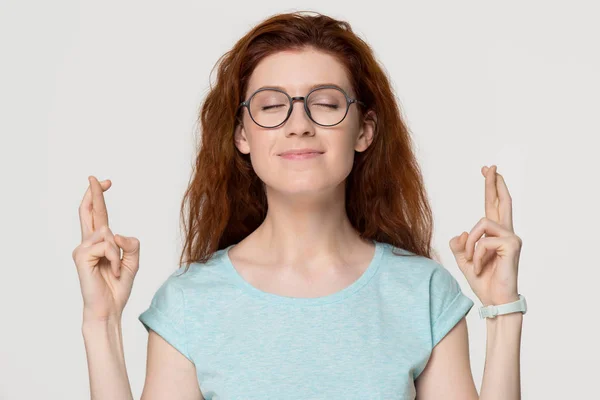 Superstitious redhead woman crossing fingers wishing for good luck — Stock Photo, Image