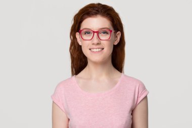 Pembe gözlük gülümseyen Kızıl saçlı genç kadın portresi headshot