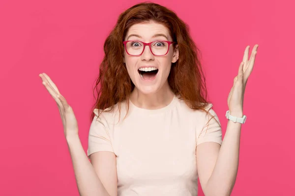 Glücklich rothaarige junge Frau fühlt sich als Siegerin isoliert auf rosa Hintergrund — Stockfoto