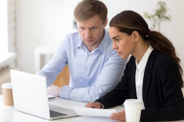 Takım arkadaşları birlikte işyerinde oturup bilgisayarla çalışma