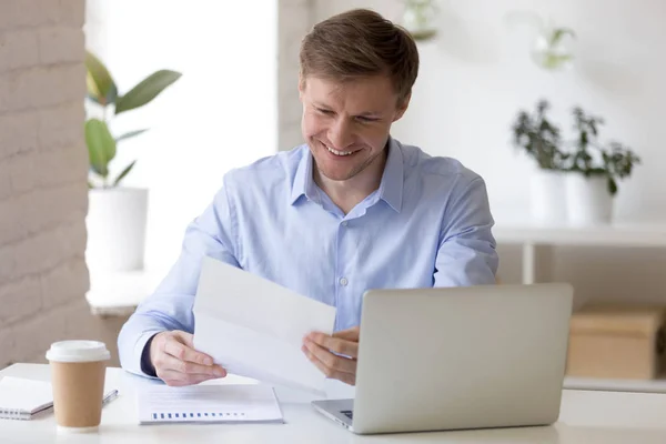 Homme d'affaires satisfait assis au bureau lettre de lecture — Photo