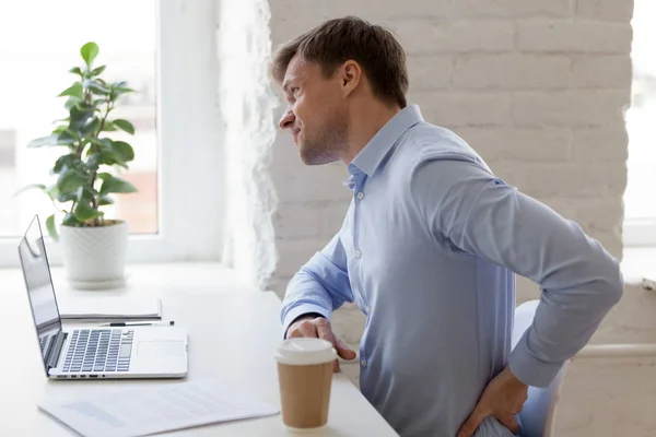 Office worker having strong lower back pain — Stock Photo, Image