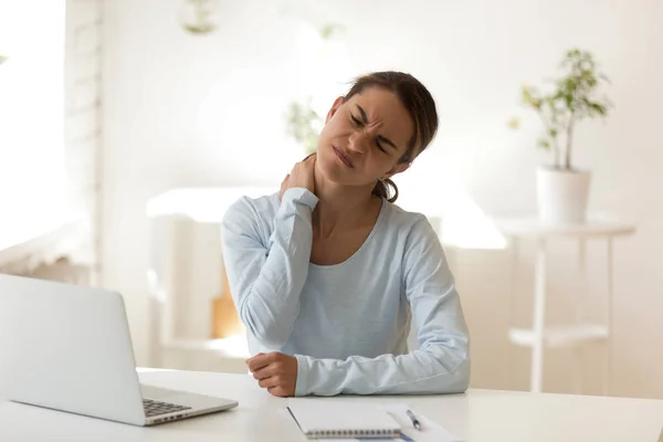 Young female suffers from neck ache at workplace — Stock Photo, Image