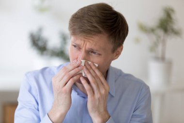 Kağıt mendil tutan ve burun üfleme adam