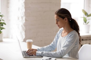 Kadın oturma dizüstü kullanarak işyeri manifatura konsantre